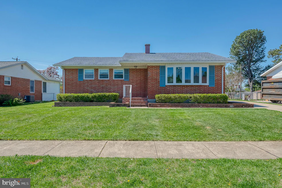 Brick ranch-style house with a gray roof, blue shutters, and a well-kept green lawn.