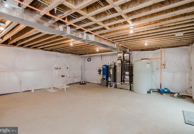 Unfinished basement utility room with exposed joists, ductwork, and HVAC equipment along the back wall.